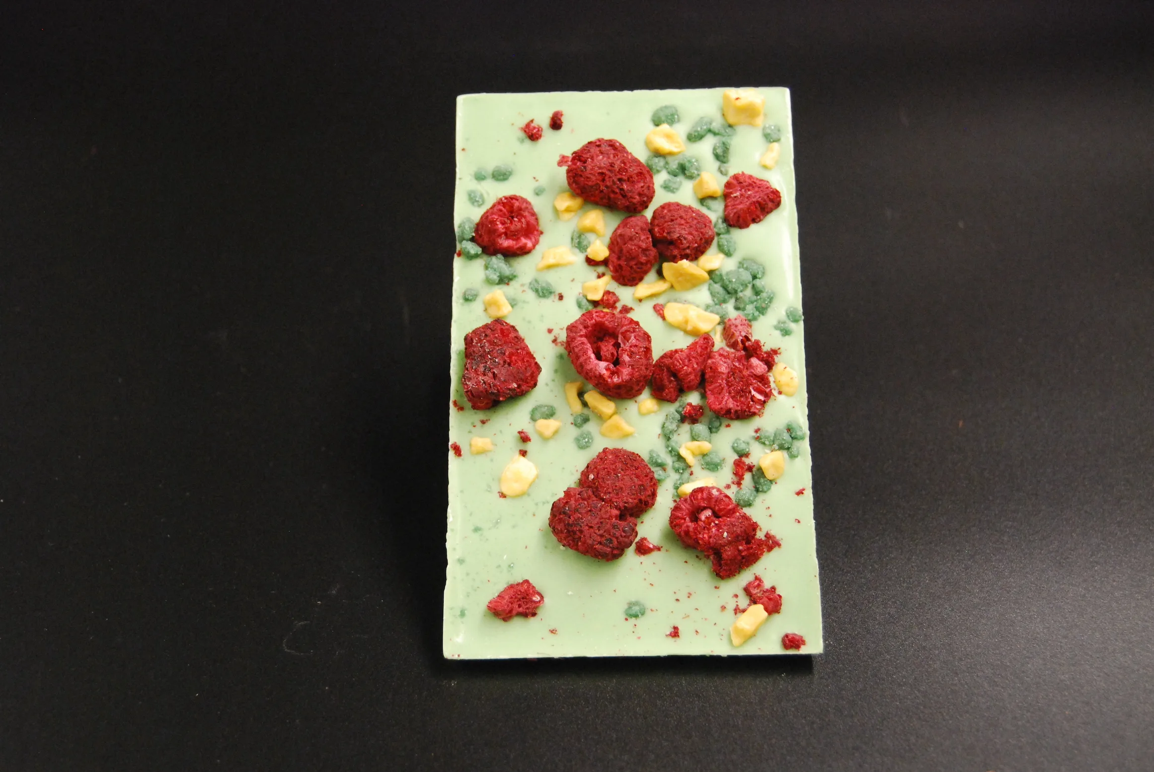 Lemonlade Tafel aus weißer Schokolade mit Himbeeren, kristallisierter Minze und Passionsfrucht-Crispy – handgefertigt in Michis Schokoatelier in Frankfurt