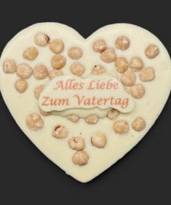 Schokoladenherz aus weißer Schokolade (36 % Kakao), mit Aufschrift „Schokoherz flach Vatertag Haselnüsse“