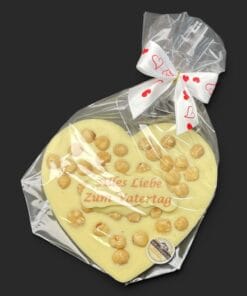 Schokoladenherz aus weißer Schokolade (36 % Kakao), mit Aufschrift „Schokoherz flach Vatertag Haselnüsse“, in Geschenkverpackung