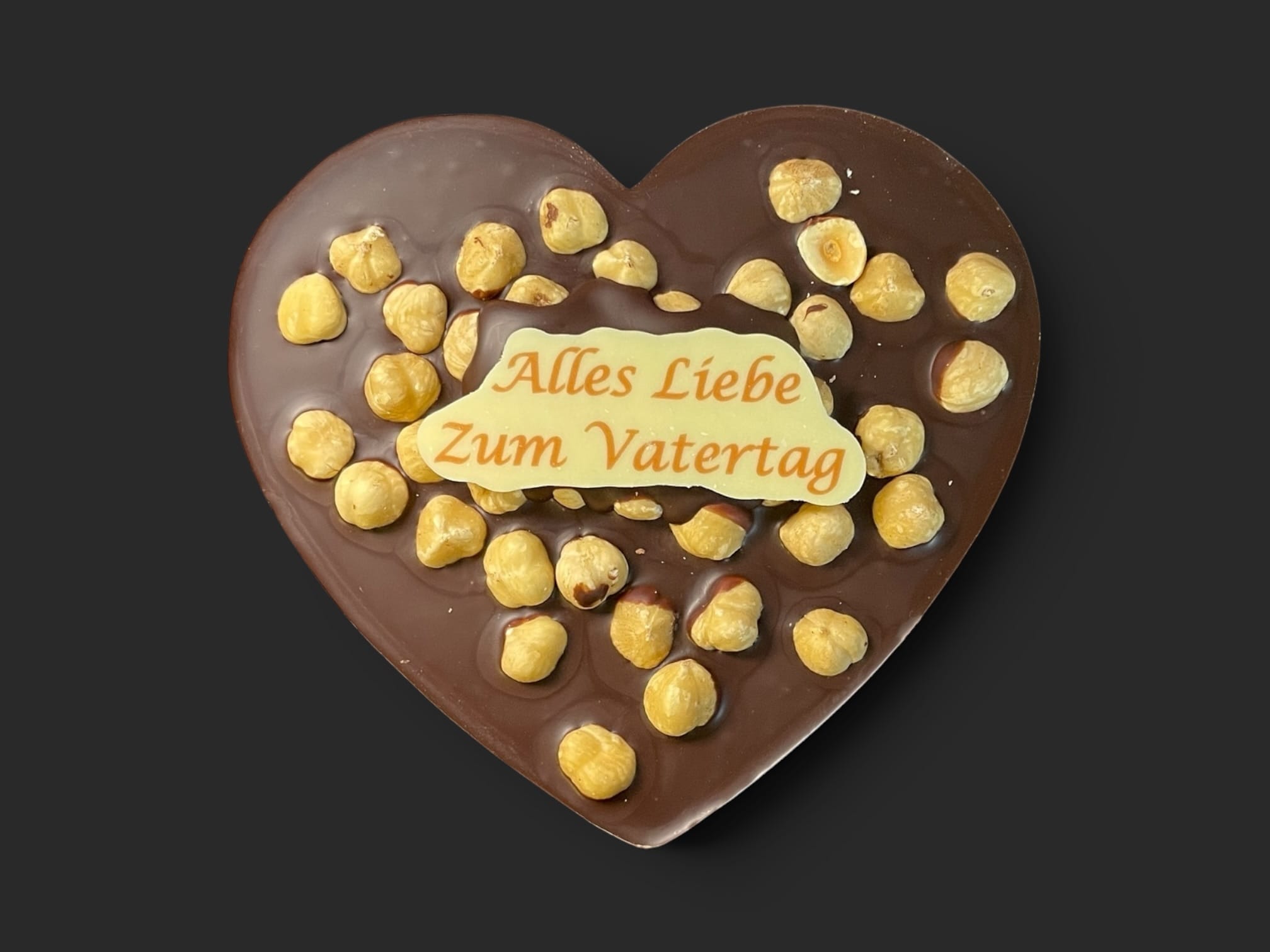 Schokoladenherz aus Zartbitterschokolade (65 % Kakao), mit Aufschrift „Schokoherz flach Vatertag Haselnüsse“