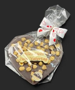 Schokoladenherz aus Zartbitterschokolade (65 % Kakao), mit Aufschrift „Schokoherz flach Vatertag Haselnüsse“, in Geschenkverpackung