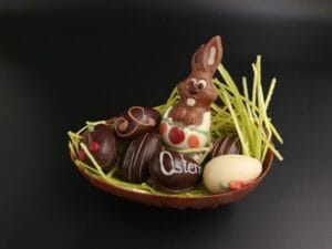Großes Halbes Osterei aus Vollmilch-Schokolade, gefüllt mit 6 Pralinen-Ostereiern und einem kleinen Osterhasen aus Vollmilch-Schokolade