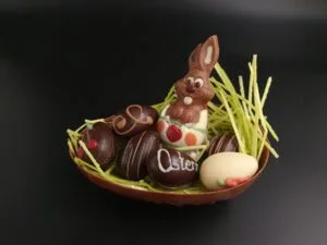 Großes Halbes Osterei aus Vollmilch-Schokolade, gefüllt mit 6 Pralinen-Ostereiern und einem kleinen Osterhasen aus Vollmilch-Schokolade