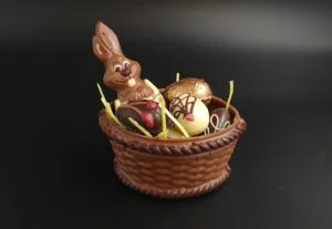 Schokokorb aus Vollmilchschokolade gefüllt mit sechs Pralineneiern und einem kleinen Schokoladenhasen