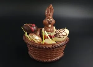 Schokokorb aus Vollmilchschokolade gefüllt mit sechs Pralineneiern und einem kleinen Schokoladenhasen